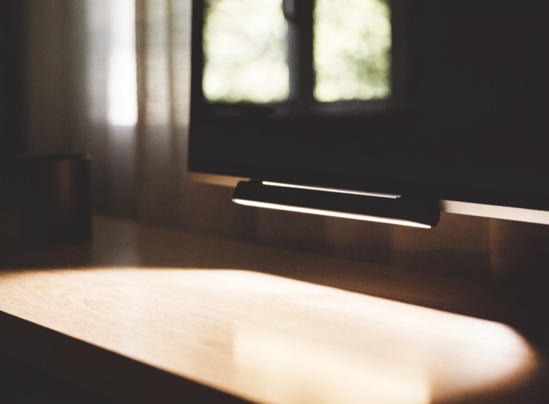 A monitor light bar clipped to a screen, lighting the desk below