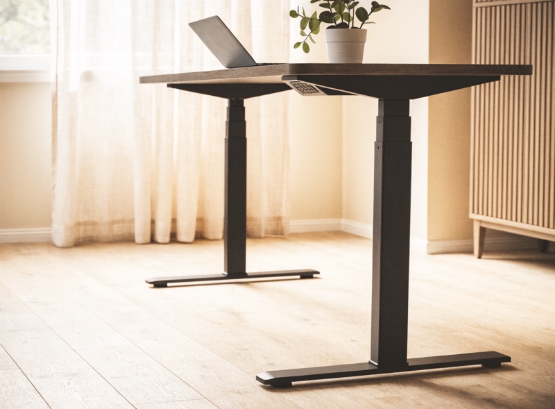 A standing desk raised to standing height in a warm home office